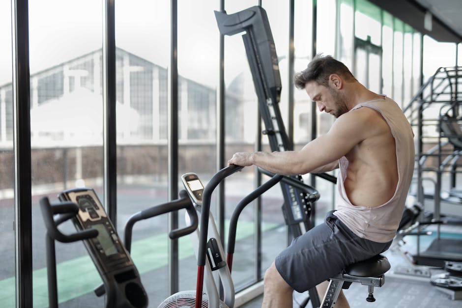 Focused man working out on a stationary bike in a modern gym.