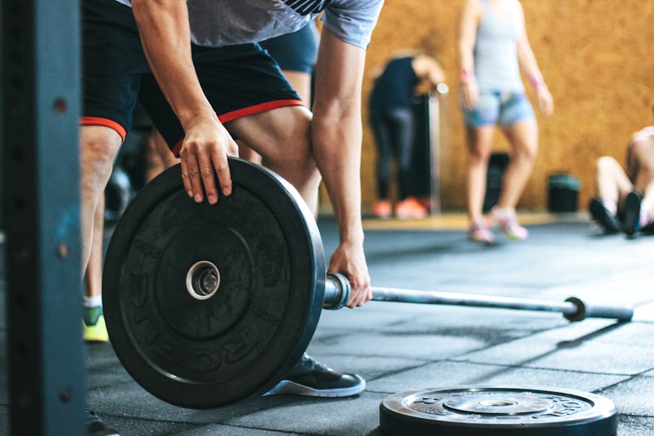 Focused weightlifting session in a gym with diverse athletes participating indoors.